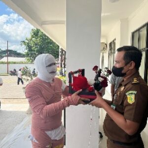 Direktur LOGIS-NTB Fihiruddin menyerahkan paket pakaian dalam wanita kepada Kasi Intel Anak Agung Kusuma Putra